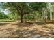 Wide view of the property showing a gated and wooden fenced yard with mature trees at 19263 Quiet Oak Ln, Brooksville, FL 34604