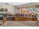 Open-concept kitchen with granite countertops, breakfast bar, and view to outdoor pool area at 19263 Quiet Oak Ln, Brooksville, FL 34604