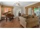 Comfortable living room with tile floors, grand piano and a large sofa, perfect for relaxation at 19263 Quiet Oak Ln, Brooksville, FL 34604