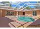 Covered pool area, surrounded by rock landscaping at 19263 Quiet Oak Ln, Brooksville, FL 34604
