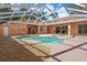 Covered pool area with pebble landscaping and multiple entry points to the home at 19263 Quiet Oak Ln, Brooksville, FL 34604
