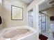 Bright bathroom with a tiled shower, soaking tub, and neutral colors at 3555 Sylvan Edge Dr, Palm Harbor, FL 34685