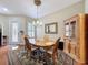 Formal dining room with hardwood floors, decorative chandelier, and elegant furnishings next to a door with glass at 3555 Sylvan Edge Dr, Palm Harbor, FL 34685