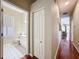 Hallway view into the bathroom with white vanity and plantation shutters at 3555 Sylvan Edge Dr, Palm Harbor, FL 34685