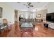 Comfortable living room featuring hardwood floors, ceiling fan, and access to the dining room and other areas at 3555 Sylvan Edge Dr, Palm Harbor, FL 34685