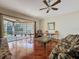 Relaxing living area with hardwood floors, ceiling fan, sliding glass doors to the patio, and natural lighting at 3555 Sylvan Edge Dr, Palm Harbor, FL 34685
