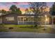 Charming single-story home featuring brown siding, a cozy front porch, and a well-maintained lawn at sunset at 3728 Linkwood St, New Port Richey, FL 34652