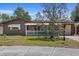 Charming single-story home featuring a white picket fence, covered porch, and well-maintained yard, creating inviting curb appeal at 3728 Linkwood St, New Port Richey, FL 34652