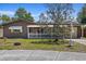 Charming single-story home featuring brown siding, a cozy front porch, and a well-maintained lawn at 3728 Linkwood St, New Port Richey, FL 34652