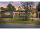 Charming home featuring a manicured lawn, a white picket fence, and lovely exterior lighting at 3728 Linkwood St, New Port Richey, FL 34652