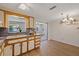 Kitchen with light-colored cabinets, laminate countertops and view into another room with chandelier at 3728 Linkwood St, New Port Richey, FL 34652