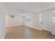 Bright living room with wood-look floors, a ceiling fan, and a front door at 3728 Linkwood St, New Port Richey, FL 34652