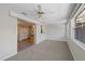 Carpeted living room with a ceiling fan and open access to the kitchen area through sliding doors at 3728 Linkwood St, New Port Richey, FL 34652