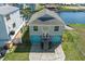 Aerial view of a two-story waterfront home showcasing blue garage doors, and spacious backyard at 4046 Casa Ct, Hernando Beach, FL 34607