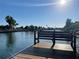 Wooden dock with bench offering a serene waterfront view, ideal for relaxing by the water at 4046 Casa Ct, Hernando Beach, FL 34607