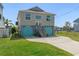 Two-story waterfront home featuring blue garage doors, stairs to the front door, and well-kept lawn at 4046 Casa Ct, Hernando Beach, FL 34607
