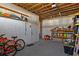 Spacious garage with exposed wood ceilings, shelving, workspace and a door to the outside at 4046 Casa Ct, Hernando Beach, FL 34607