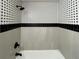 Modern bathroom with sleek black fixtures, a new tub, and stylish black and white tile work at 4601 N 37Th St, Tampa, FL 33610