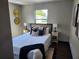 Cozy bedroom with a comfortable bed, wood floors, two side tables, and a sunny window at 4601 N 37Th St, Tampa, FL 33610