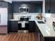 Modern kitchen features stainless steel appliances, dark cabinetry and white countertops at 4601 N 37Th St, Tampa, FL 33610