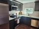 Well-designed kitchen with stainless steel appliances, dark cabinets, and light countertop at 4601 N 37Th St, Tampa, FL 33610