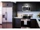 Modern kitchen featuring stainless steel appliances, dark cabinets, and white countertops at 4601 N 37Th St, Tampa, FL 33610