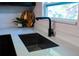 Stylish black faucet over a stainless steel kitchen sink with white countertops at 4601 N 37Th St, Tampa, FL 33610