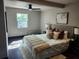 Bright main bedroom with hardwood floors, a ceiling fan, and plush bedding at 4601 N 37Th St, Tampa, FL 33610
