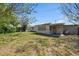 View of the backyard featuring a patio area and a house with mature trees at 4743 Foothill Dr, Holiday, FL 34690