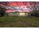 Backyard view with a beautiful sunset and lush green grass at 4743 Foothill Dr, Holiday, FL 34690