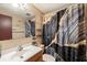 Bathroom featuring tiled walls, a modern black and gold shower curtain, and updated fixtures at 4743 Foothill Dr, Holiday, FL 34690