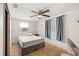 Cozy bedroom with a ceiling fan, window AC unit, and neutral decor; tiled floors and grey curtains at 4743 Foothill Dr, Holiday, FL 34690
