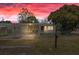 Charming home with a carport, fenced yard, and mailbox under a vivid sunset sky at 4743 Foothill Dr, Holiday, FL 34690