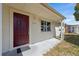 Exterior shot of home with a red front door, white siding, and visible address number at 4743 Foothill Dr, Holiday, FL 34690