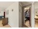 Hallway view showing bathroom entrance, dark accent door, and side table at 4743 Foothill Dr, Holiday, FL 34690