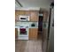 Functional kitchen with wood cabinets, white appliances, and ample counter space; stainless refrigerator at 4743 Foothill Dr, Holiday, FL 34690