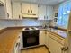 Efficient kitchen with white cabinetry, laminate countertops, and essential appliances at 4937 Marine Pkwy # 201, New Port Richey, FL 34652