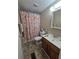 Cozy bathroom with vanity, toilet, and shower with floral shower curtain at 5211 Wisteria Cir, New Port Richey, FL 34653
