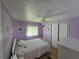 Charming bedroom featuring a large window, a ceiling fan, and closet for ample storage at 5211 Wisteria Cir, New Port Richey, FL 34653
