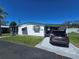 Well-maintained single-story home with green trim, manicured lawn, and paved driveway at 5211 Wisteria Cir, New Port Richey, FL 34653