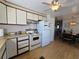 Kitchen with cabinets, appliances, and hardwood floors leading to dining area at 5211 Wisteria Cir, New Port Richey, FL 34653