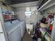 Functional laundry room with washer, dryer, utility sink, and ample storage shelves at 5211 Wisteria Cir, New Port Richey, FL 34653