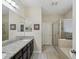 Bathroom with granite countertops, framed mirrors, tiled floors, and a glass-enclosed shower at 636 Tierra Dr, Spring Hill, FL 34609