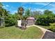 Charming storage shed with a brick path, well-manicured lawn, and mature trees at 6433 Murray Hill Dr, Tampa, FL 33615