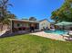 Spacious backyard featuring a screened-in patio, lush lawn, and a sparkling pool area at 7215 121St Ter, Largo, FL 33773