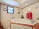 Corner bathtub with a textured surround, small window, and decorative wallpaper creating a relaxing space at 7215 121St Ter, Largo, FL 33773