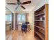 This bedroom provides a workspace with a desk, bookshelf, and a window letting in natural light, with a ceiling fan at 7215 121St Ter, Largo, FL 33773