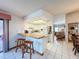 Bright kitchen featuring white cabinets, bar seating, and white tile flooring at 7215 121St Ter, Largo, FL 33773