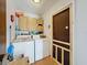 Functional laundry room with washer, dryer, and overhead cabinets for convenient storage and access to outdoor exit at 7215 121St Ter, Largo, FL 33773