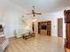 Open living area features a ceiling fan, wood-look flooring, and a TV entertainment center at 7215 121St Ter, Largo, FL 33773